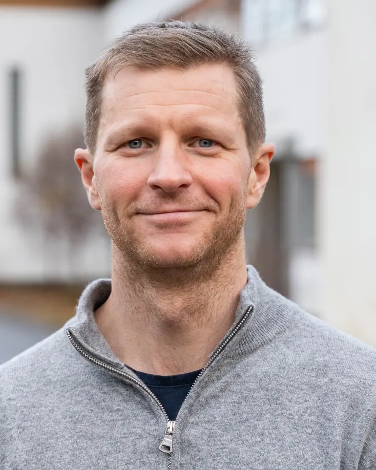En mann som smiler til kameraet