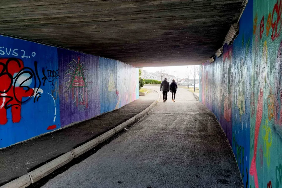 Et par personer som går nedover et fortau