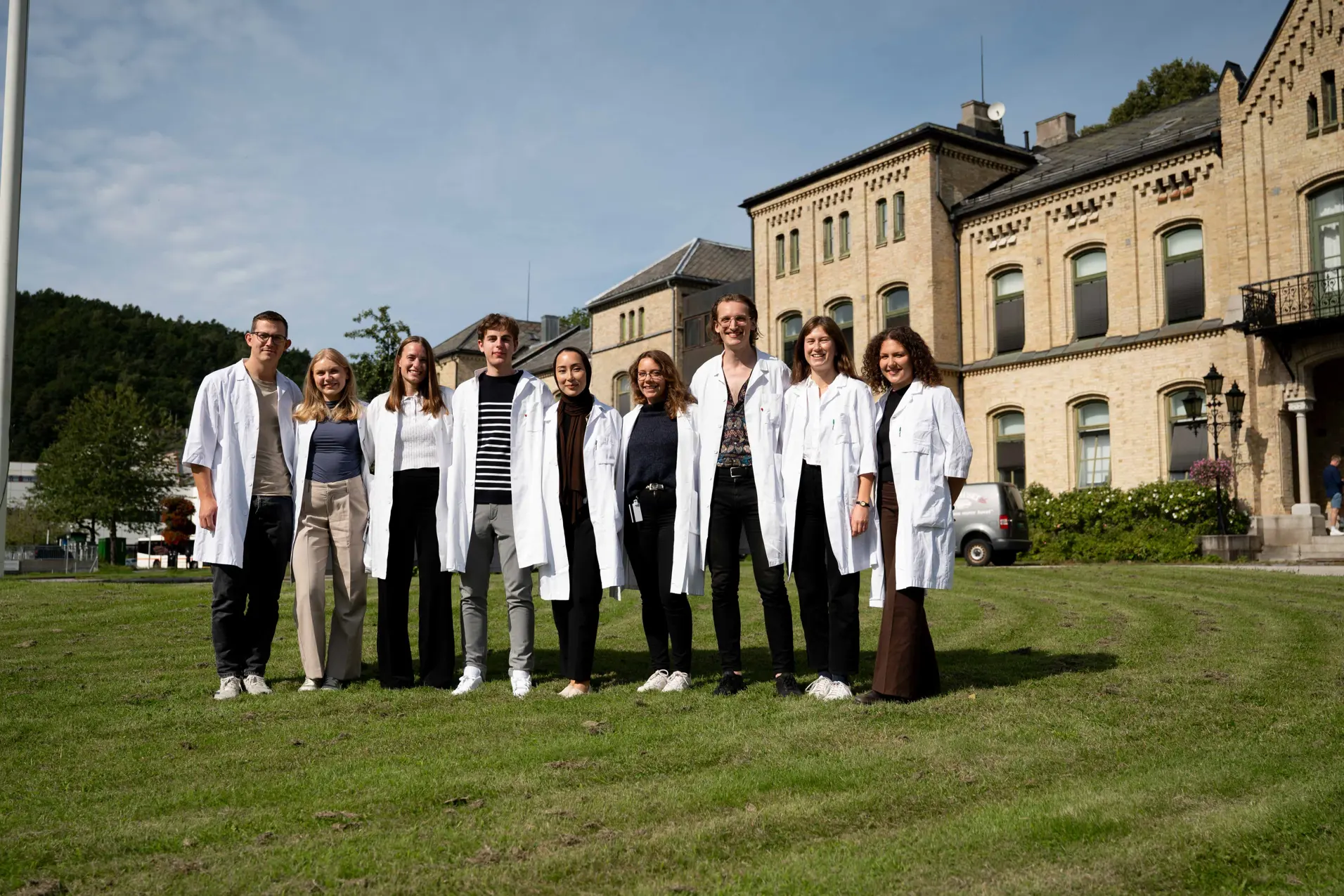 En gruppe mennesker som poserer for et bilde foran en bygning