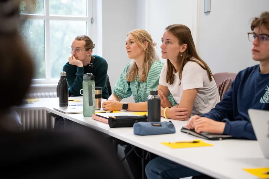 En gruppe studenter som sitter ved et bord