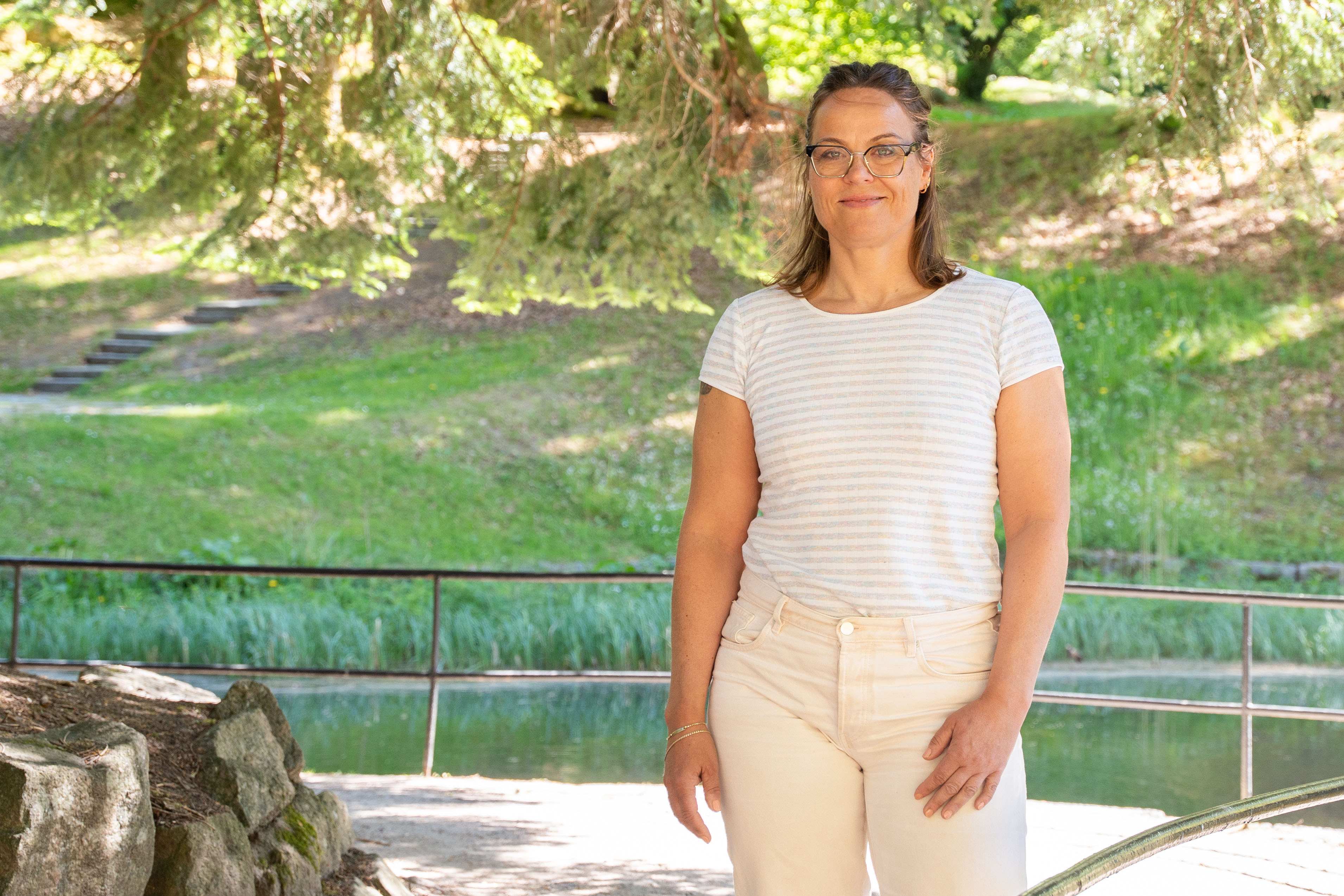 En kvinne som står ved et rekkverk i en park