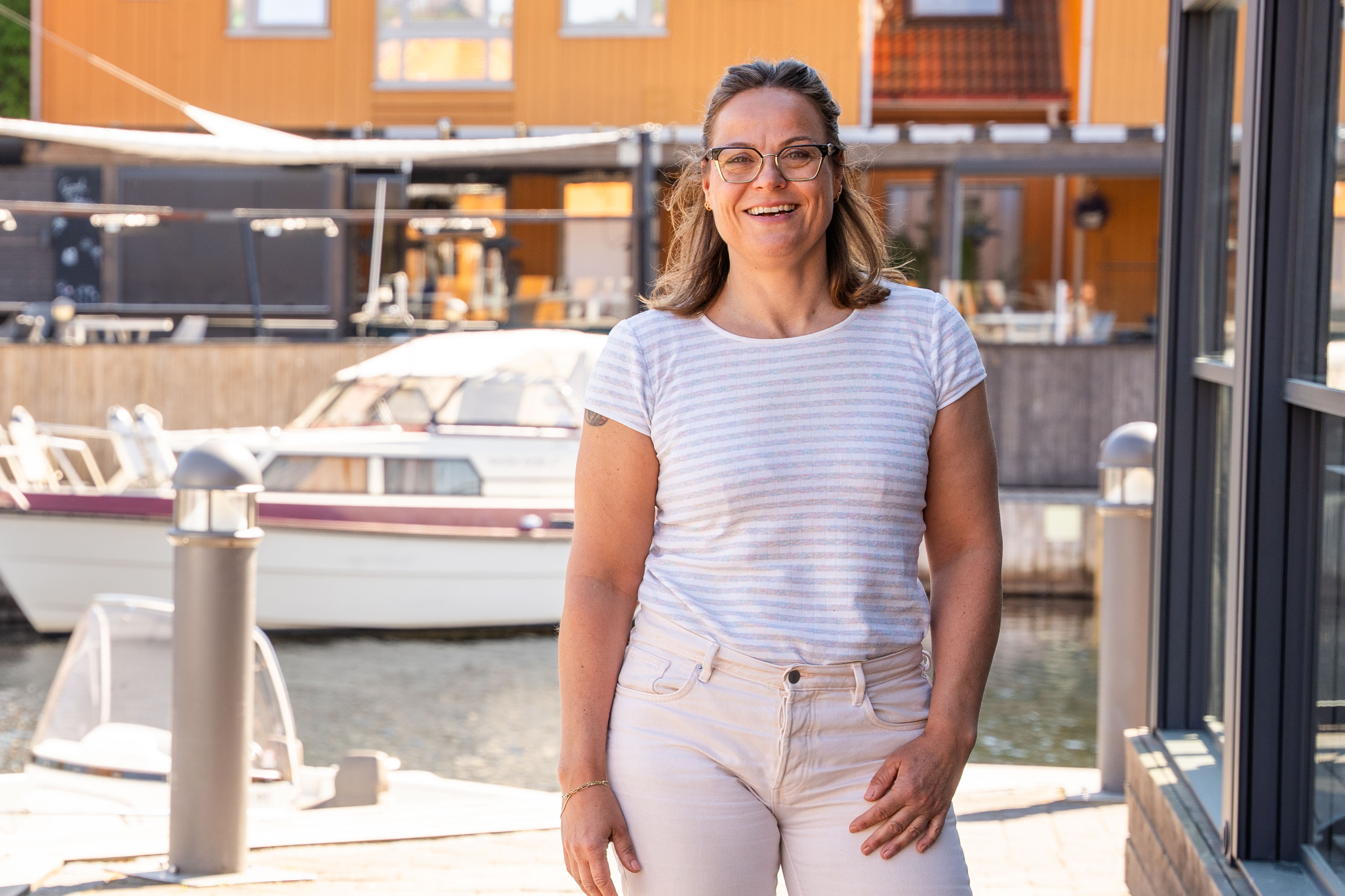 En kvinne som står foran en båt i Kristiansand