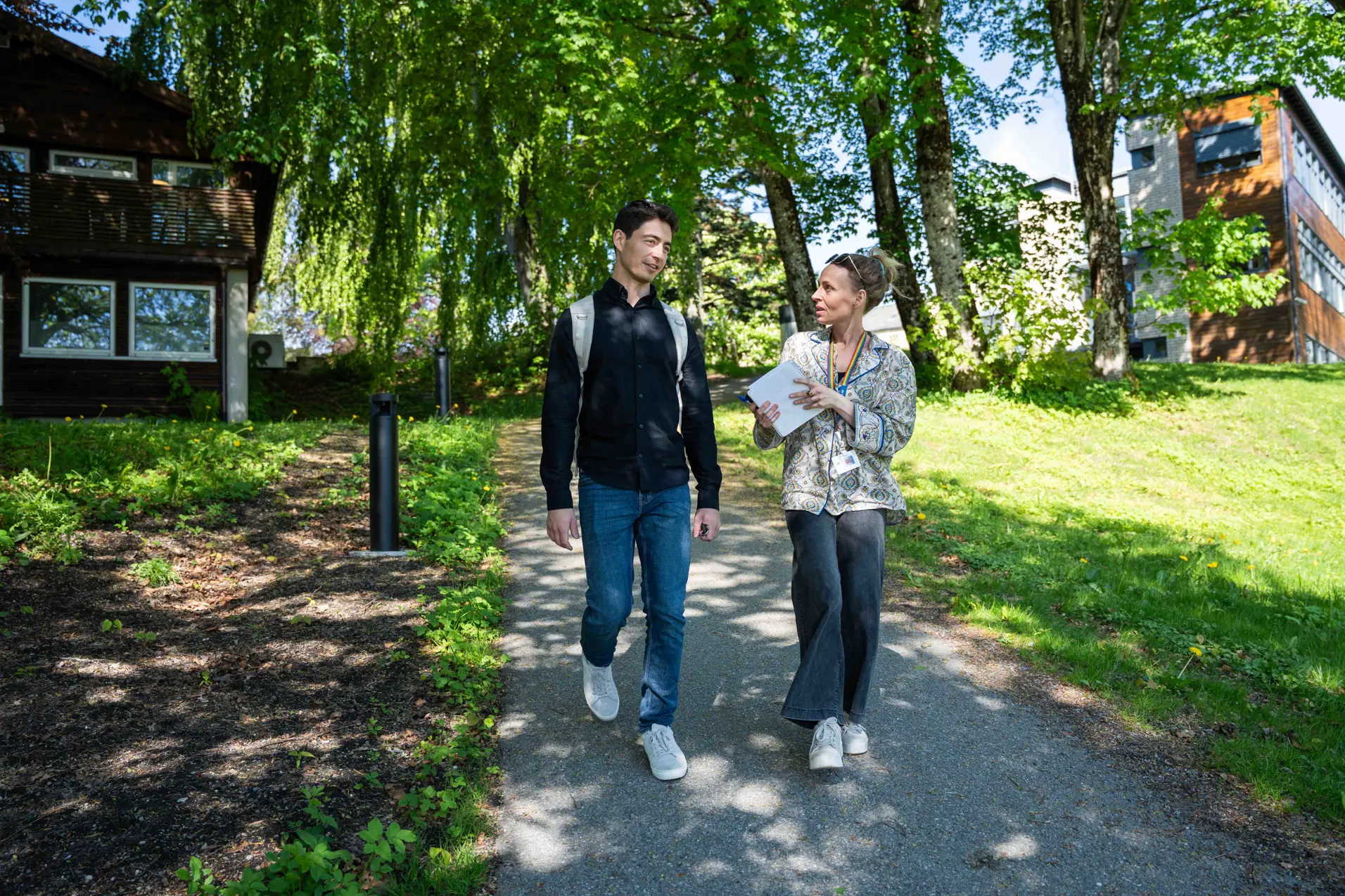 En mann og en kvinne som går ned en sti i en park
