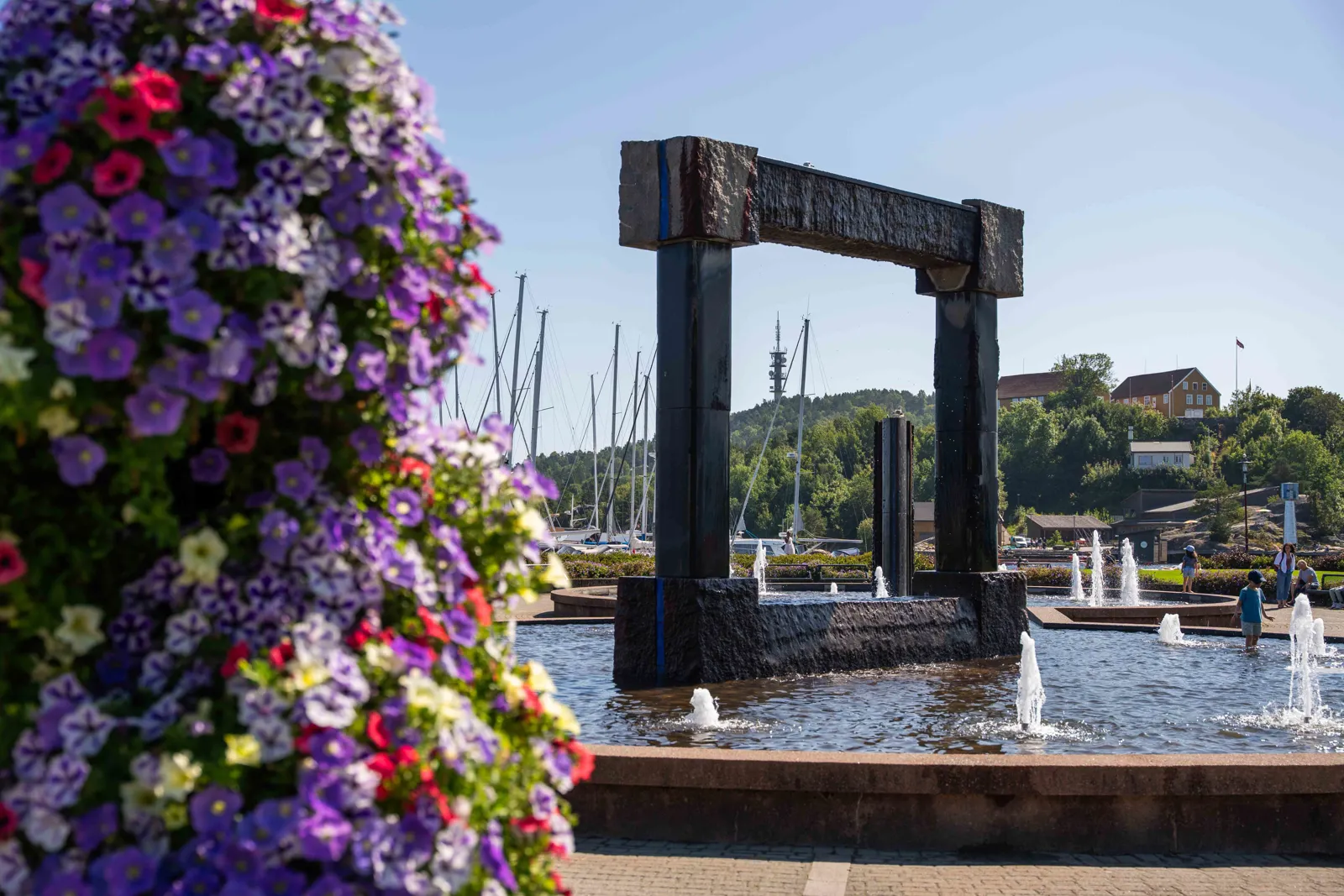En stor bue over en vannmasse med blomster på siden