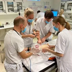 Et team av leger i hvit uniform øver seg på simulerte hendelser. Foto