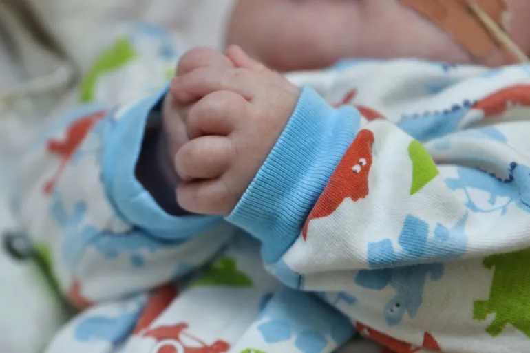 En babyhånd på et teppe