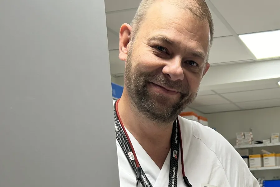 En mann som smiler til kameraet