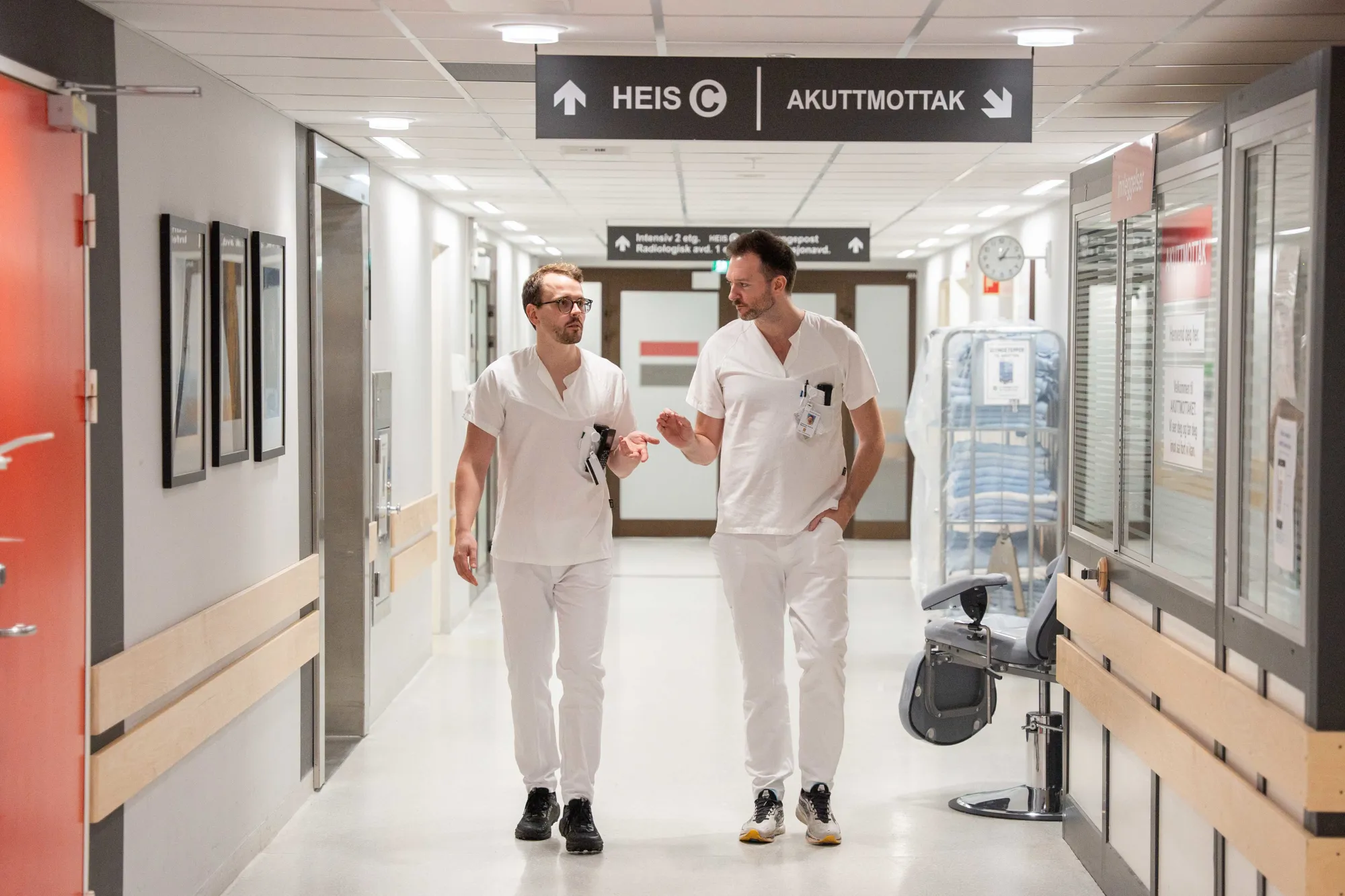 Et par menn i hvite laboratoriefrakker som går gjennom en butikk