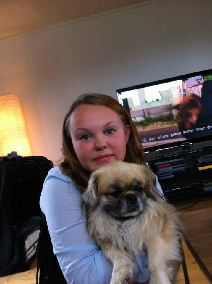 En jente som holder en hund