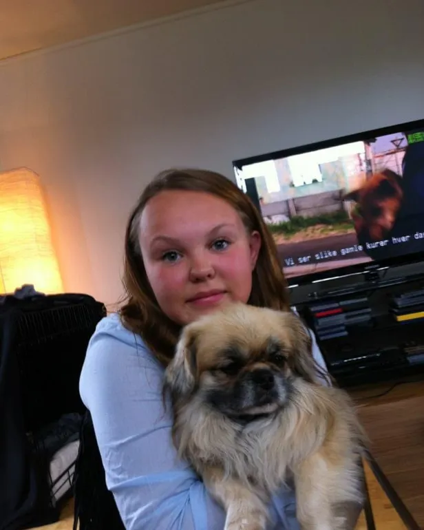 En jente som holder en hund