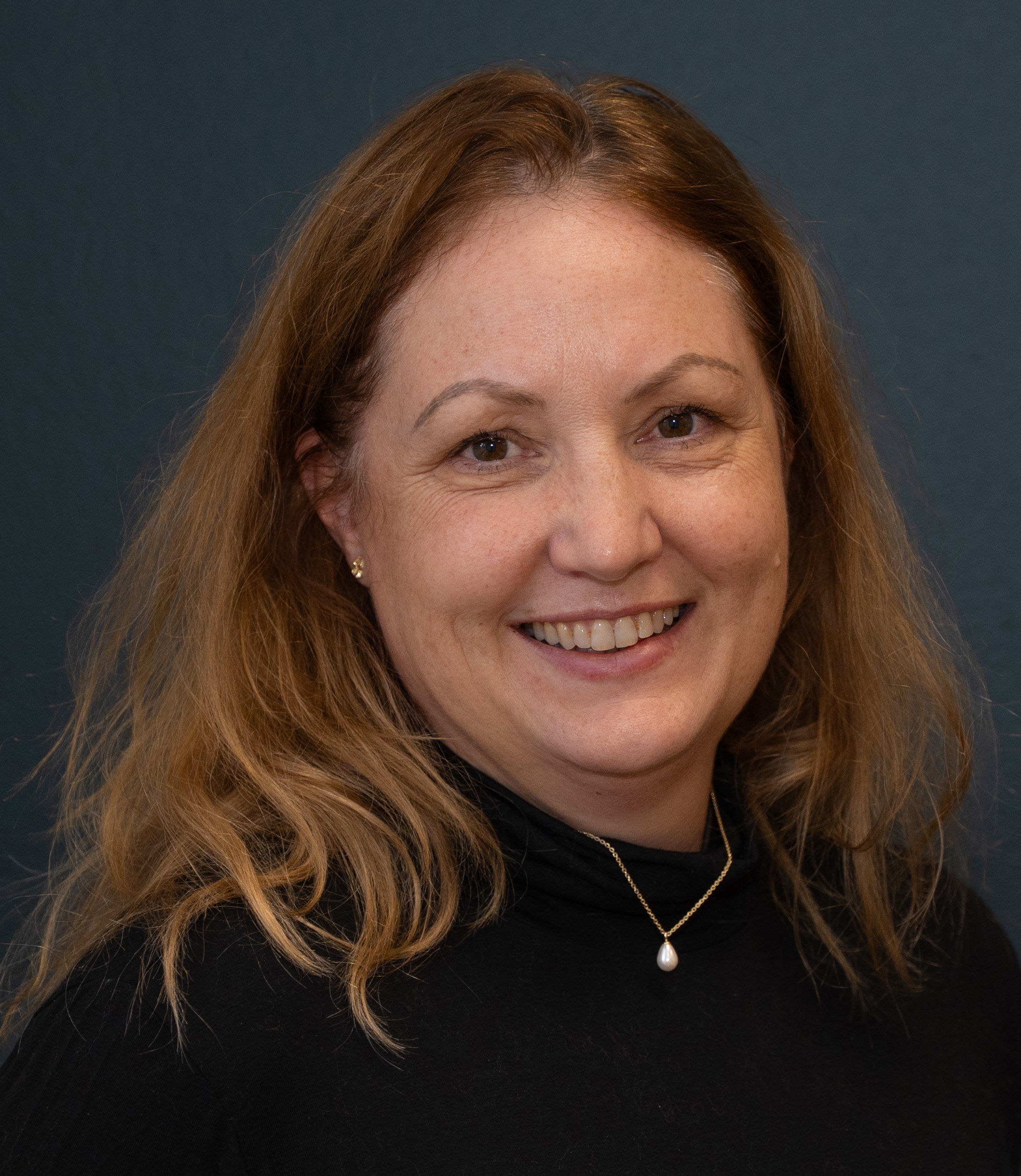 En kvinne som smiler til kameraet