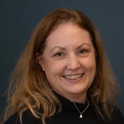 En kvinne som smiler til kameraet