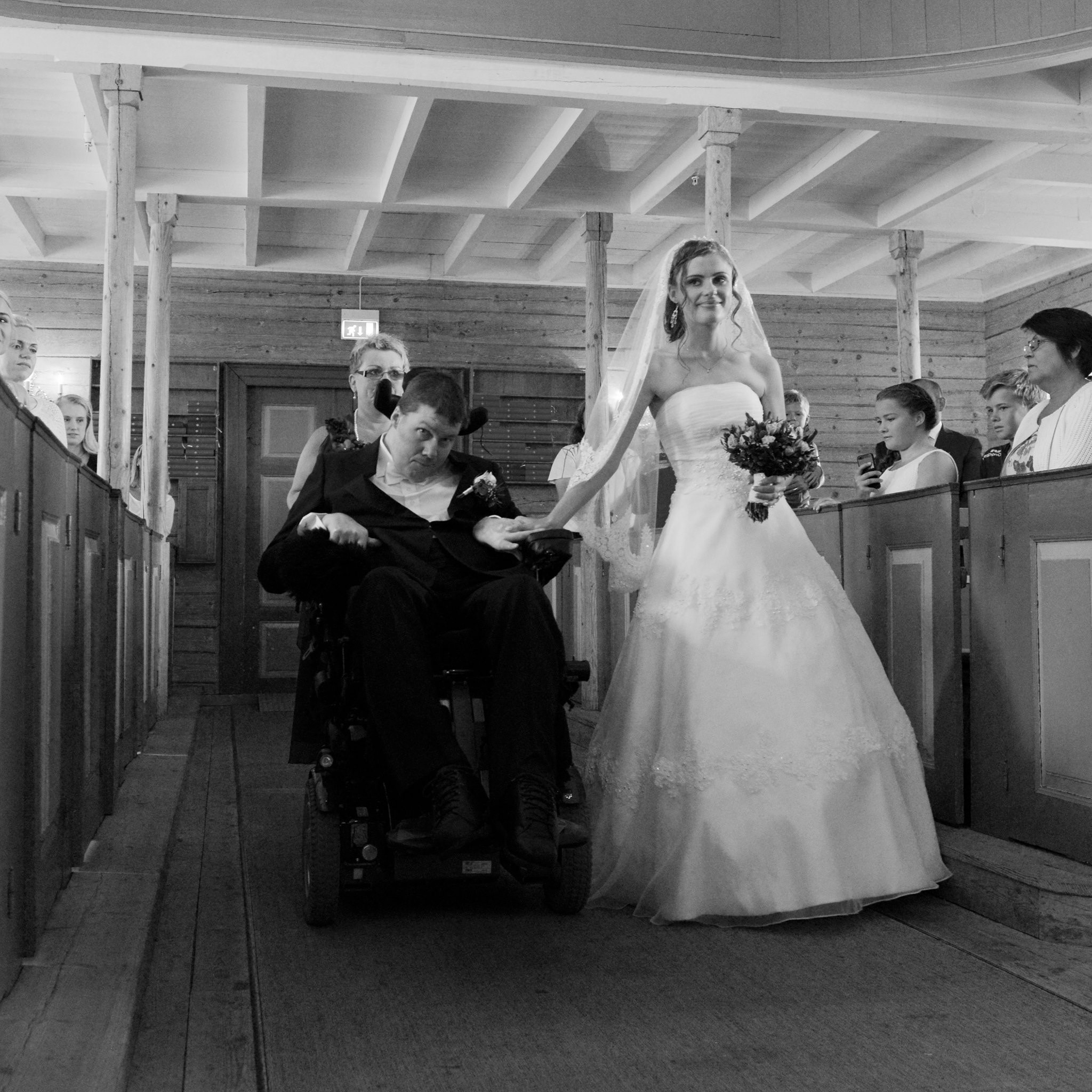 En brud og brudgom som går opp midtgangen