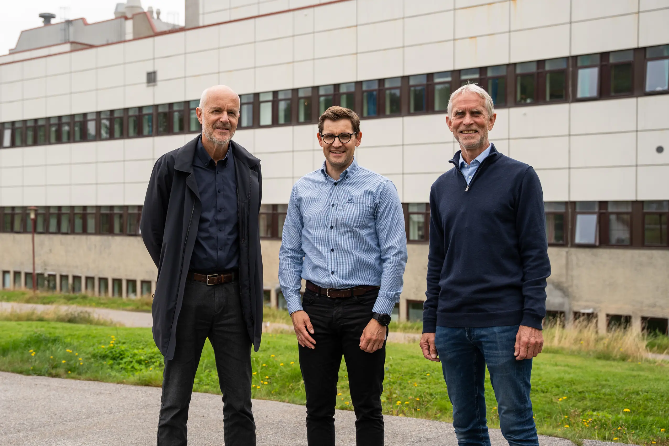 Tre menn foran sykehusbygning