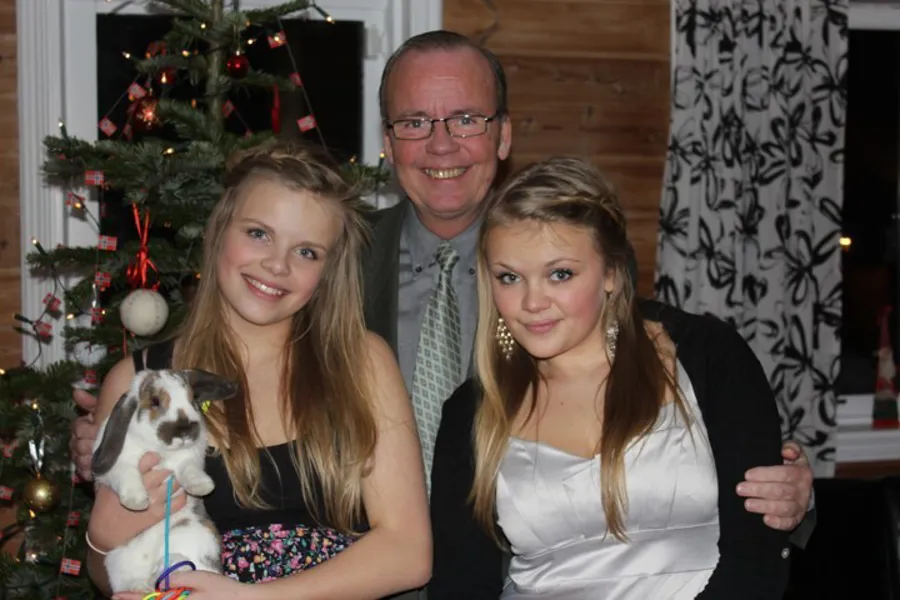 En person og to jenter poserer for et bilde